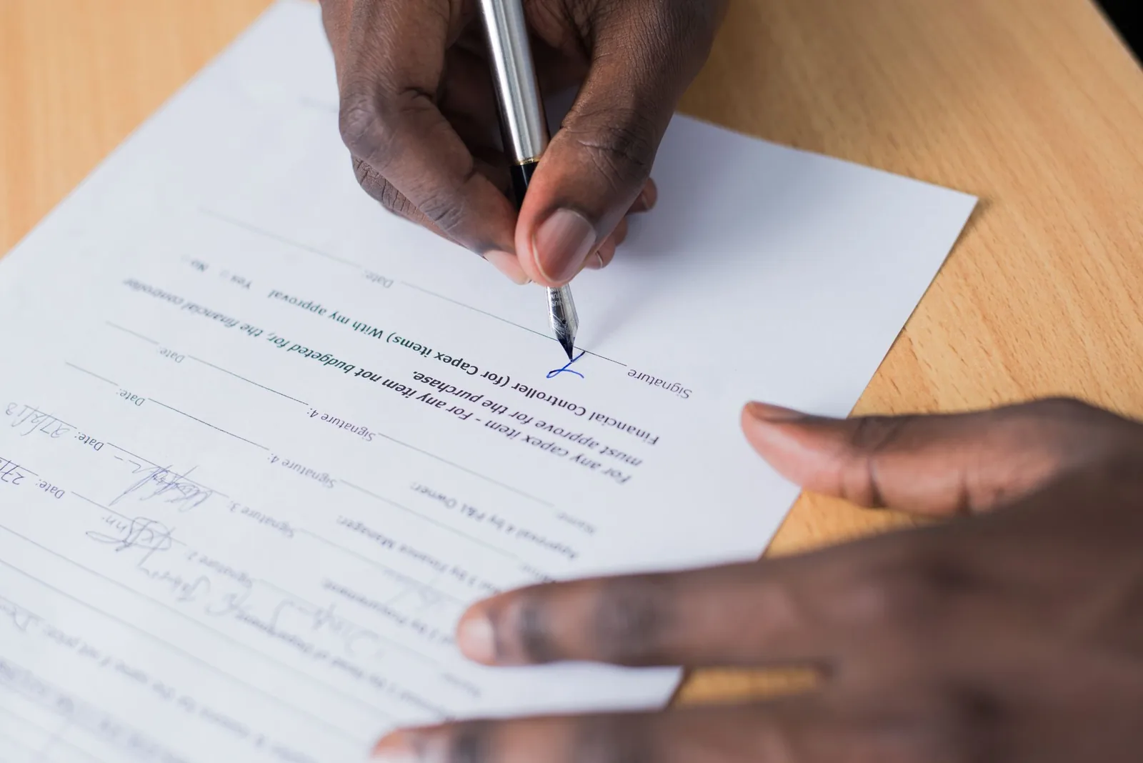 Signing a designation letter at a desk