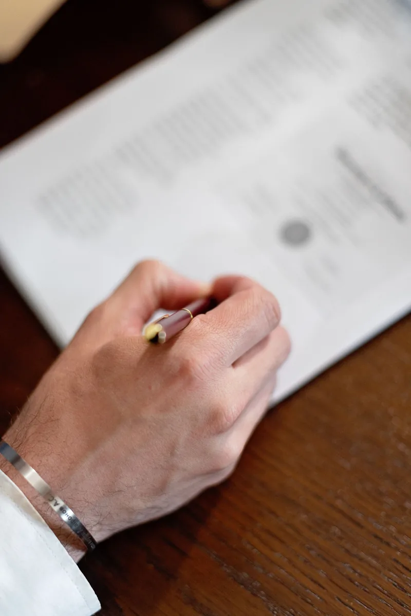Close-up of a hand signing a mandate with a fountain pen